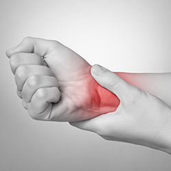 A young woman holding her painful wrist